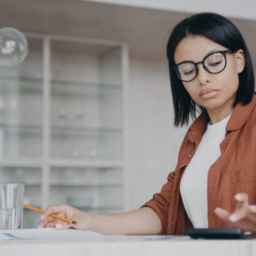 healthcare - svg xml charset utf 8 3Csvg 20xmlns 3D http 3A 2F 2Fwww - Healthcare - photo Focused female in glasses counts expenses on calculator, managing project budget, sitting at desk healthcare - svg xml charset utf 8 3Csvg 20xmlns 3D http 3A 2F 2Fwww - Healthcare