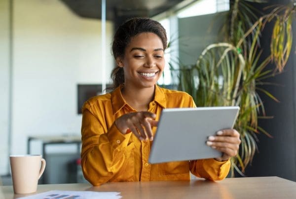 Modern technologies in business. Happy black businesswoman using modern digital tablet, working